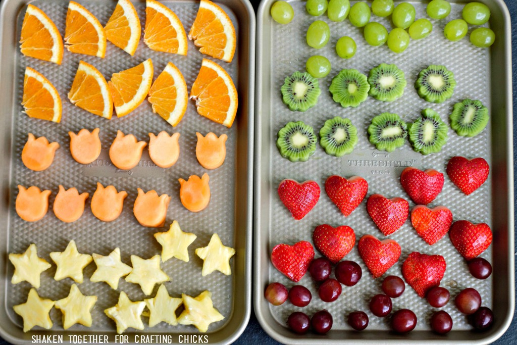 Make Rainbow Fruit Water fun by using mini cookie cutters to cut fruit into fun shapes!