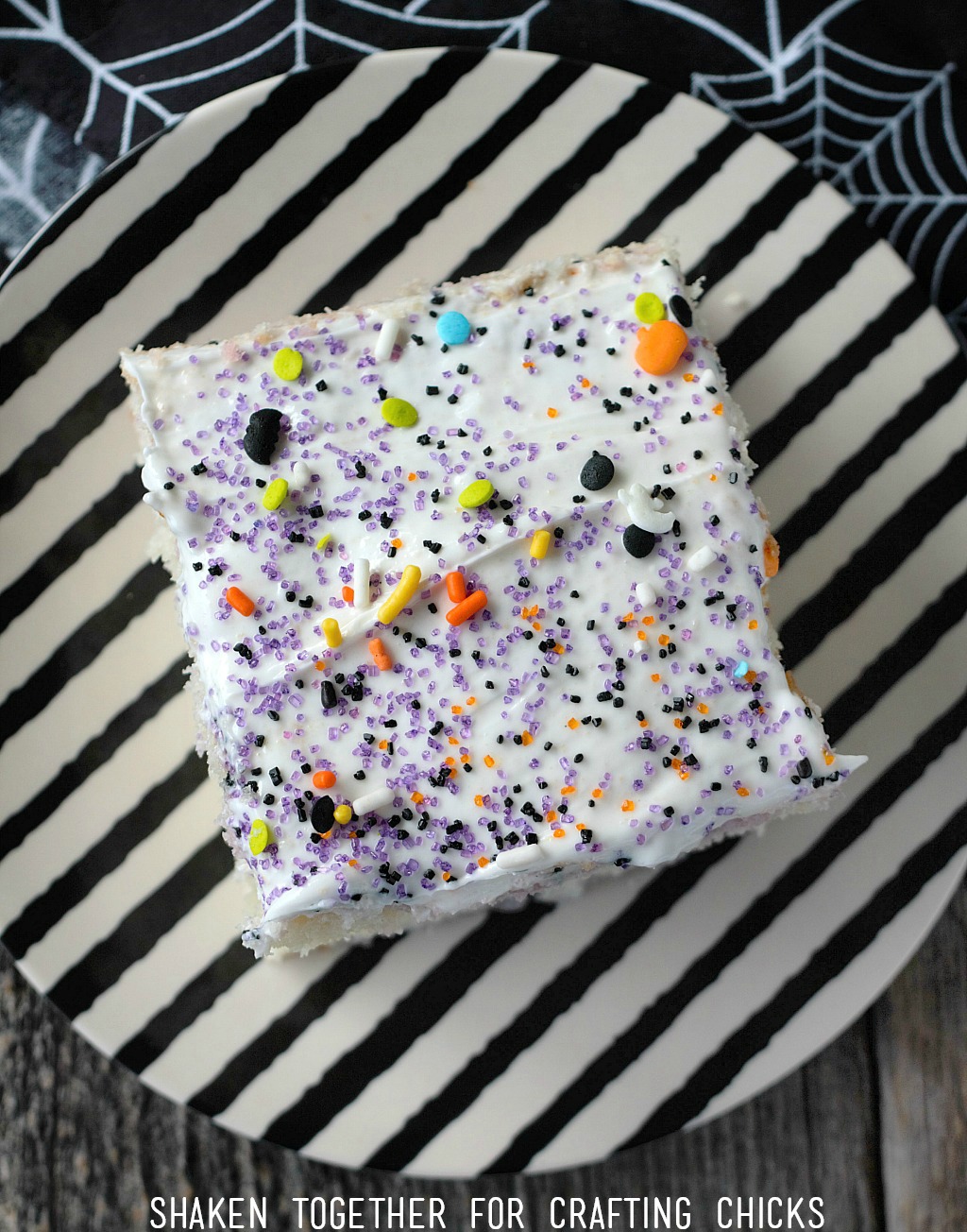 Easy Fruity Halloween Poke Cake is topped with tons of fun Halloween sugar and sprinkles!