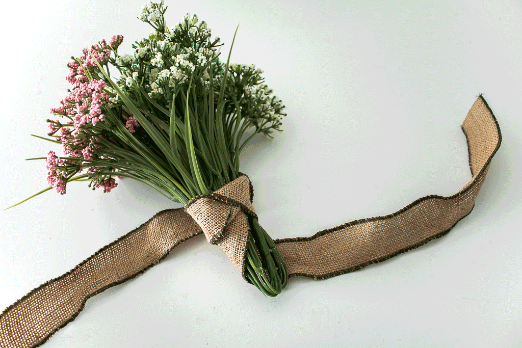 Tying a three knot ribbon on a bouquet for a spring wreath