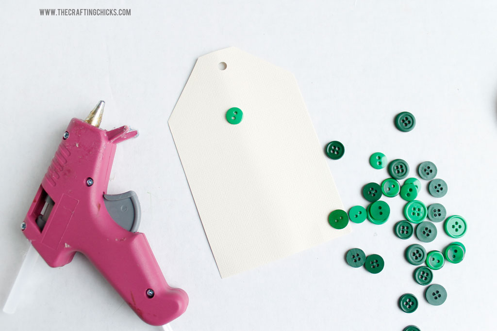 Hot glue the green buttons onto the cardstock tag to make the tree shape