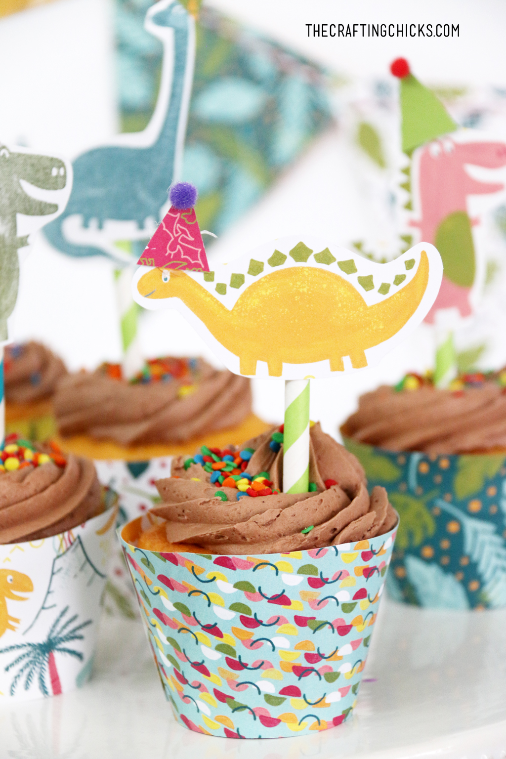 Hand stamped Dinosaurs on paper straws stuck in cupcakes. Cute Dinosaur Cupcake toppers.