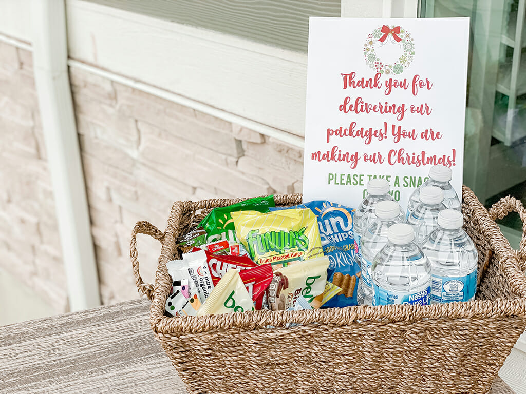 Basket filled with treats, goodies, and bottled water with a sign thanking delivery drivers