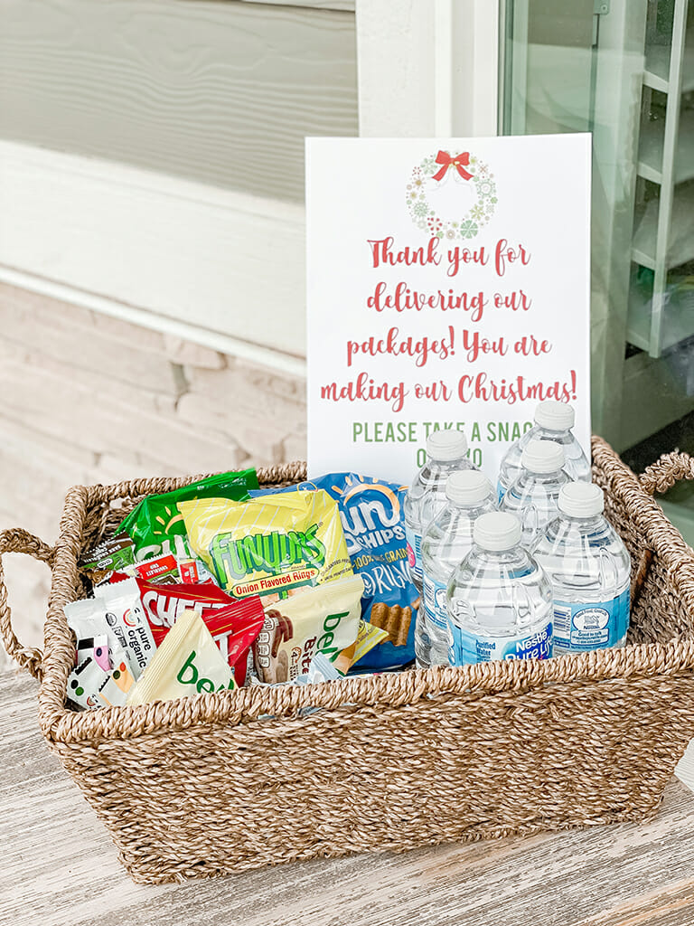 Basket filled with treats, goodies, and bottle water with a sign thanking delivery drivers.