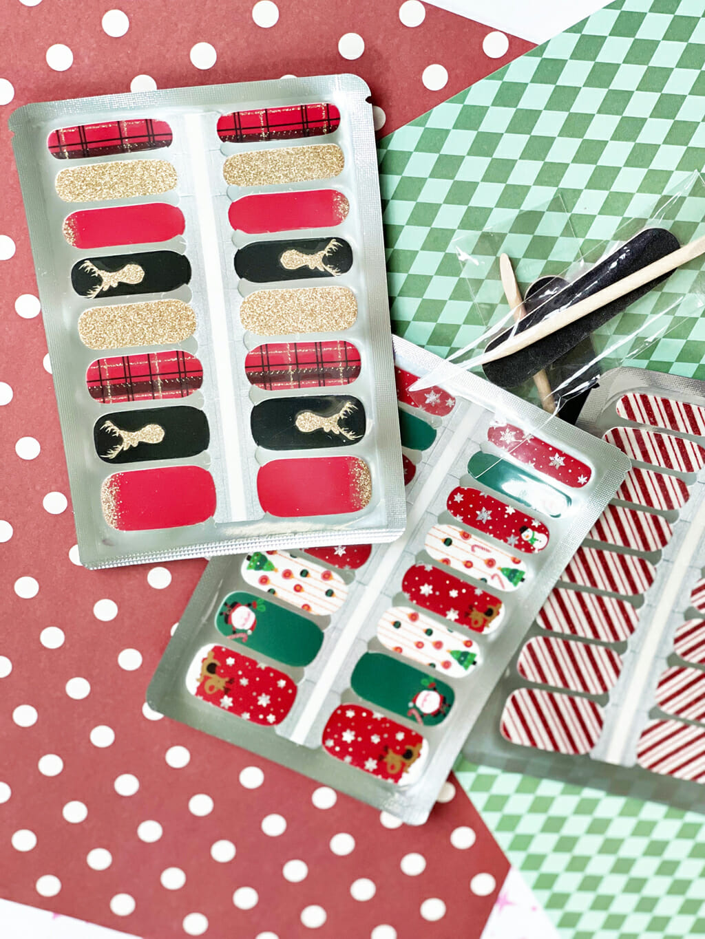 Holiday Nail Wraps on a red polka dot background and green patterned background on the side.