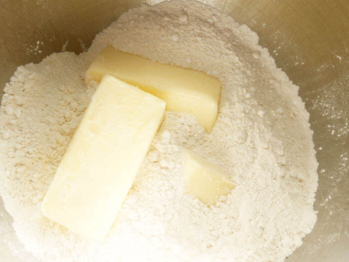 Adding butter to a dry ingredients mmixing bowl