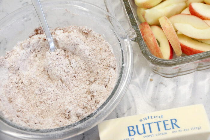 Sliced Honey Crisp apples covered with cinnamon mixture for apple crisp.