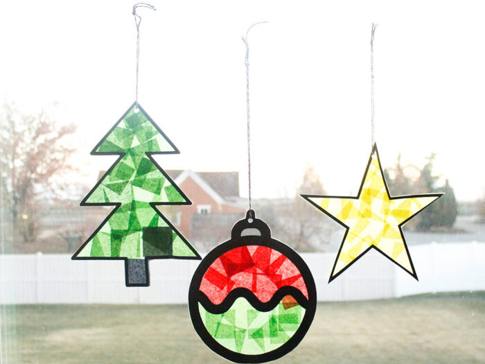 Close-up of a Christmas ornament suncatcher made with red, yellow, and green tissue paper.